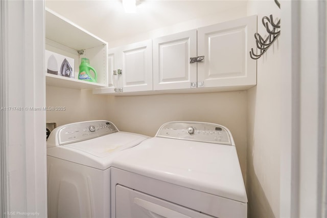 washroom with cabinets and washing machine and dryer