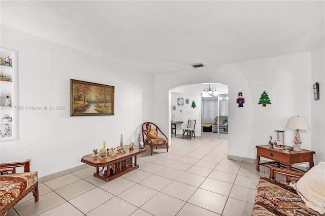 living room featuring light tile patterned floors and an inviting chandelier