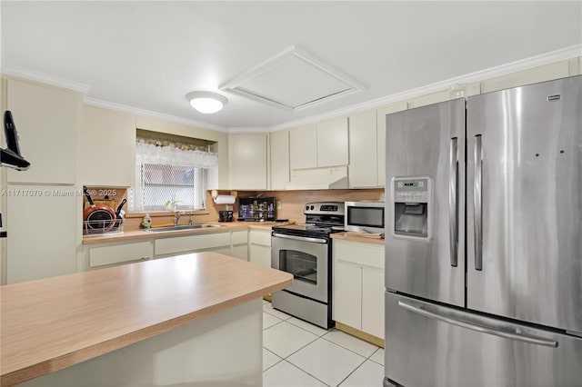 kitchen featuring crown molding, sink, appliances with stainless steel finishes, cream cabinetry, and light tile patterned flooring