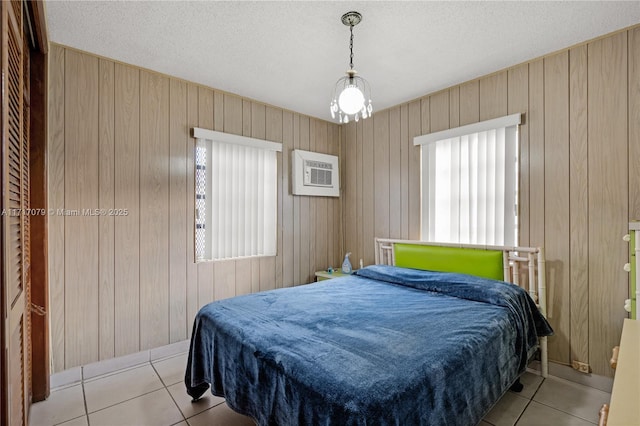 bedroom with wood walls and light tile patterned flooring