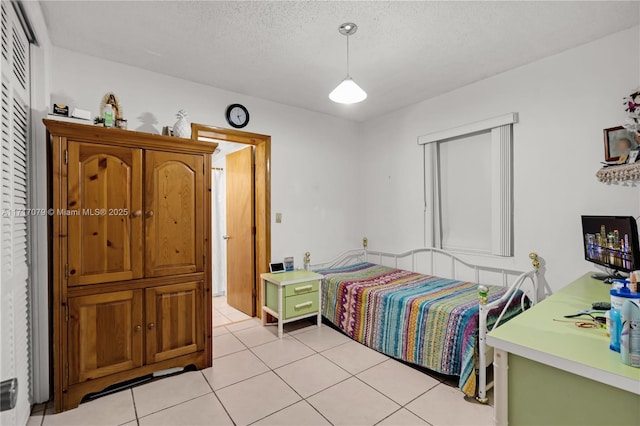 bedroom featuring light tile patterned floors and a textured ceiling