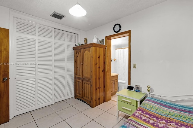 tiled bedroom featuring a closet