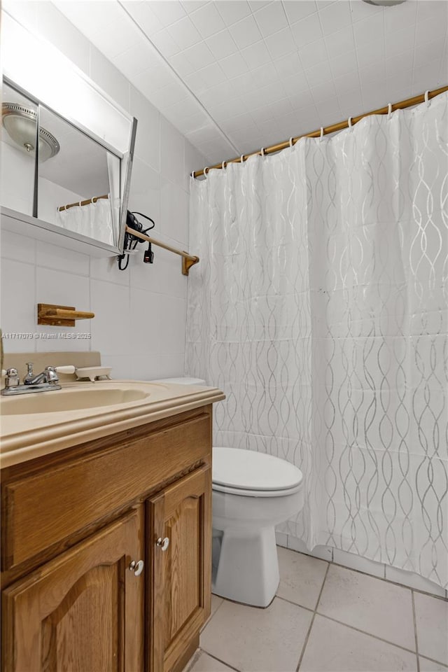 bathroom with toilet, vanity, and tile patterned floors