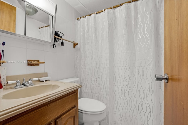 bathroom with vanity, curtained shower, toilet, and tile walls