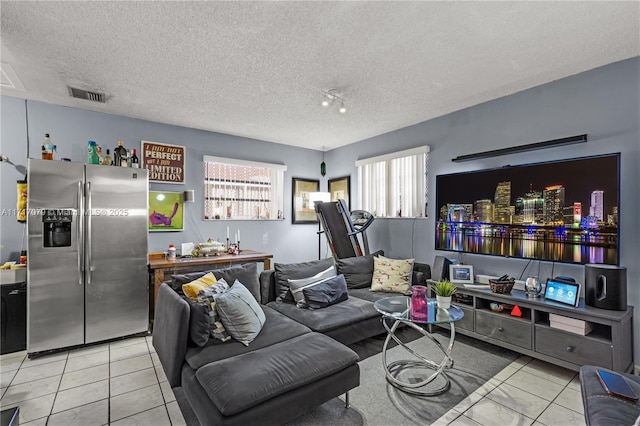 tiled living room featuring a textured ceiling