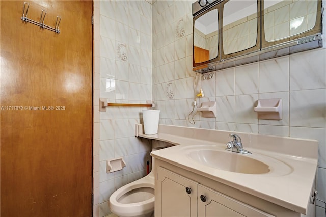 bathroom with tasteful backsplash, vanity, and tile walls