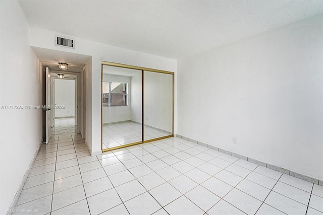 unfurnished bedroom featuring light tile patterned floors and a closet