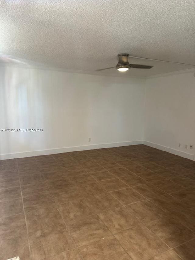 spare room with a textured ceiling and ceiling fan