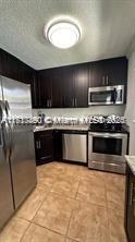 kitchen featuring light tile patterned flooring and stainless steel appliances