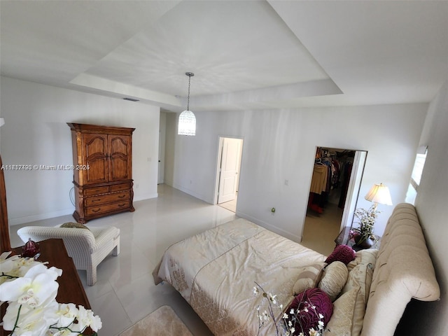 bedroom with a raised ceiling and a closet