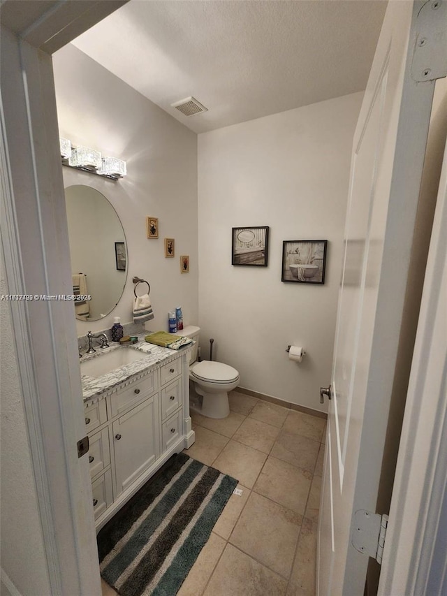 bathroom featuring tile patterned flooring, vanity, and toilet