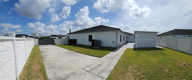 view of side of property with a yard and central AC unit