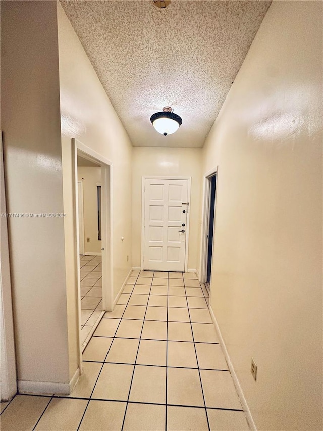 entryway featuring light tile patterned flooring and a textured ceiling