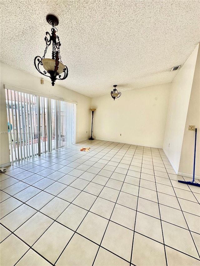 empty room with light tile patterned floors and a textured ceiling