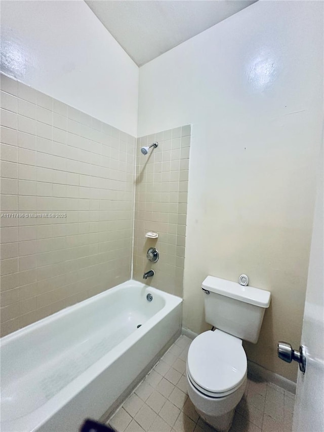 bathroom featuring tile patterned floors, toilet, and tiled shower / bath