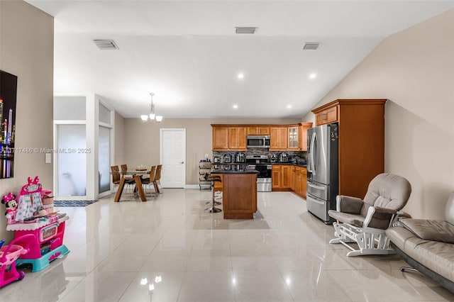 kitchen with a center island, stainless steel appliances, tasteful backsplash, a kitchen breakfast bar, and lofted ceiling