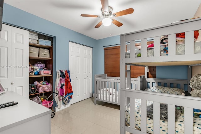 tiled bedroom featuring ceiling fan and a nursery area