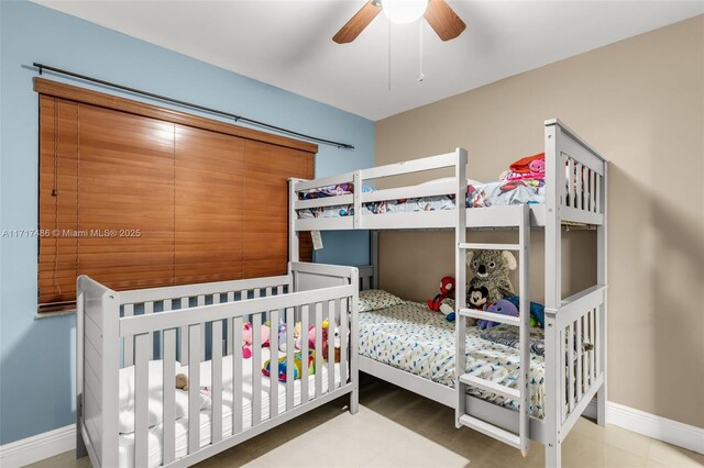 bedroom featuring a nursery area and ceiling fan