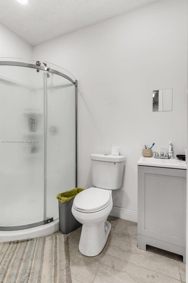 bathroom with vanity, toilet, and a shower with door