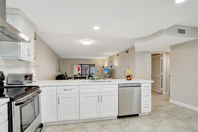 kitchen with kitchen peninsula, appliances with stainless steel finishes, wall chimney exhaust hood, sink, and white cabinets