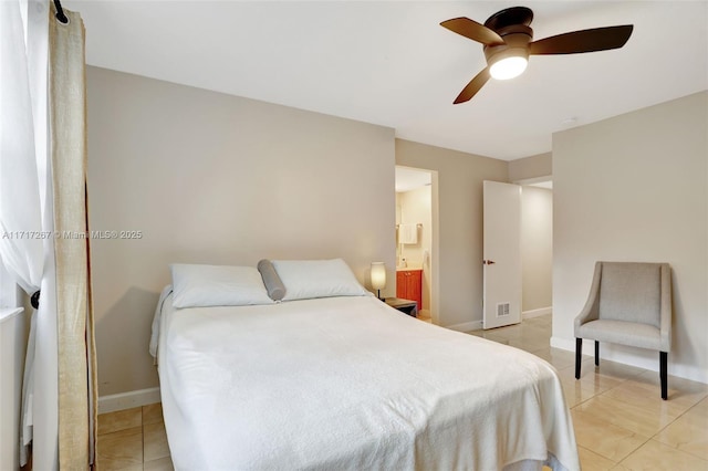 bedroom featuring light tile patterned floors, ensuite bathroom, and ceiling fan