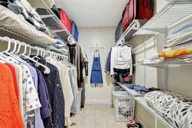 walk in closet with light tile patterned floors