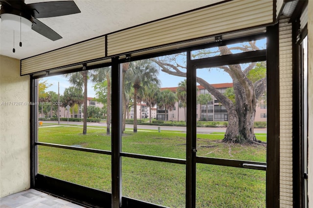 unfurnished sunroom featuring ceiling fan