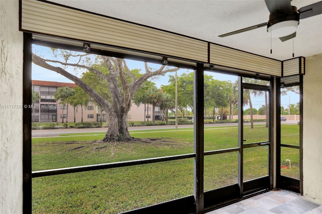 unfurnished sunroom featuring ceiling fan