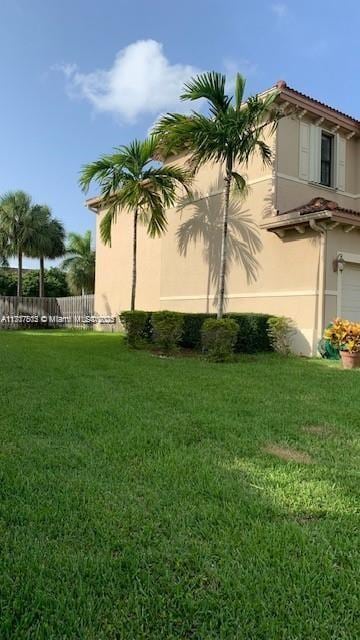 view of property exterior featuring a lawn and a garage