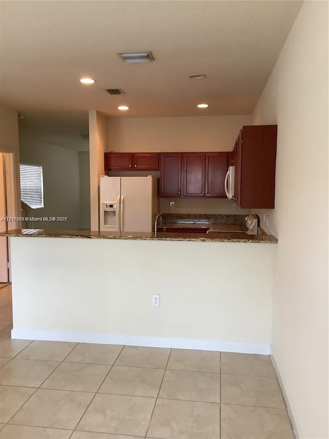 kitchen with kitchen peninsula, white appliances, sink, and light tile patterned flooring