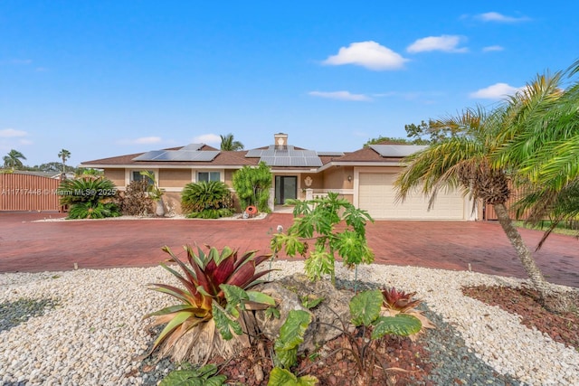 view of front of home with a garage and solar panels