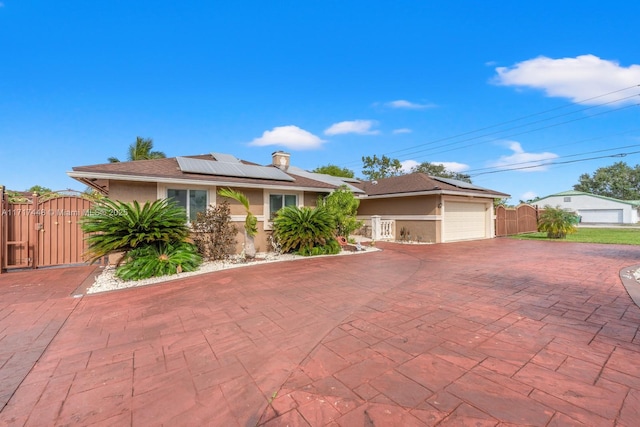 ranch-style home with solar panels and a garage