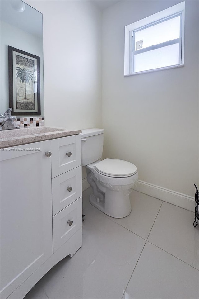 bathroom with tile patterned flooring, vanity, and toilet