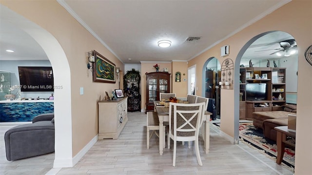 dining space featuring ceiling fan, light hardwood / wood-style floors, and crown molding