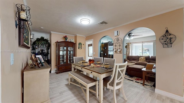 dining area with ceiling fan, ornamental molding, a textured ceiling, and light hardwood / wood-style flooring