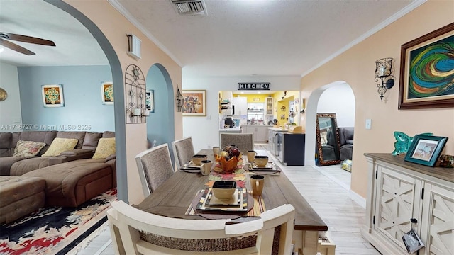 dining room featuring crown molding, ceiling fan, and light wood-type flooring