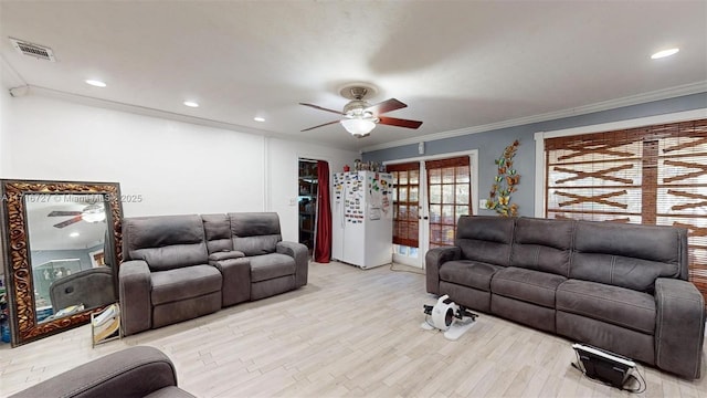 living room with crown molding and light wood-type flooring