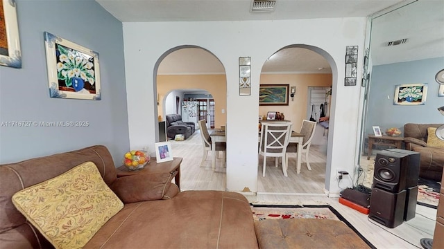 living room featuring ornamental molding and light hardwood / wood-style flooring