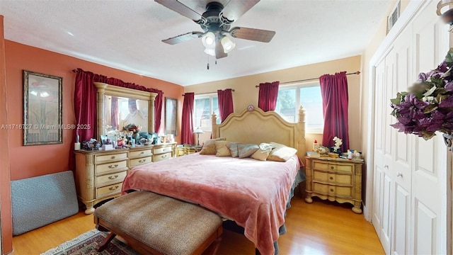 bedroom with ceiling fan, a closet, and light hardwood / wood-style floors