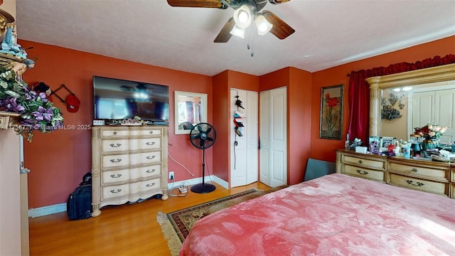 bedroom with a textured ceiling, hardwood / wood-style flooring, and ceiling fan