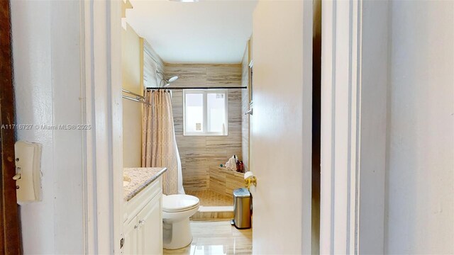 bathroom with toilet, vanity, and a shower with shower curtain