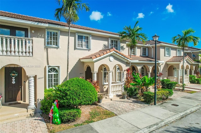 mediterranean / spanish-style home featuring a porch and a balcony