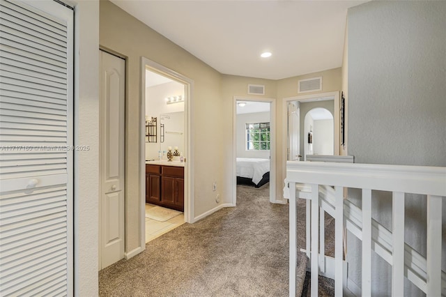 hallway with light colored carpet