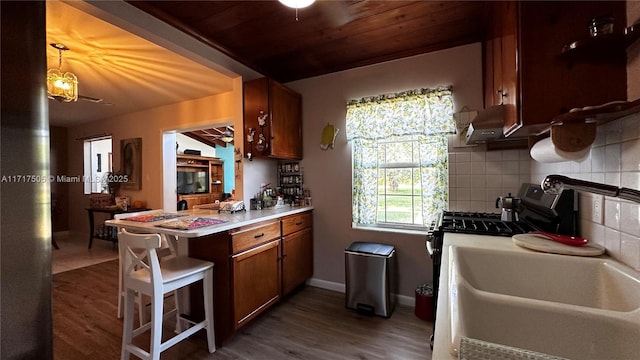 kitchen with sink, wooden ceiling, dark hardwood / wood-style flooring, decorative backsplash, and exhaust hood