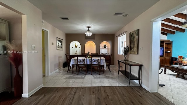 dining area with light hardwood / wood-style flooring and beamed ceiling