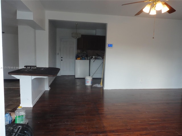 interior space featuring washer and dryer, ceiling fan, and dark wood-type flooring