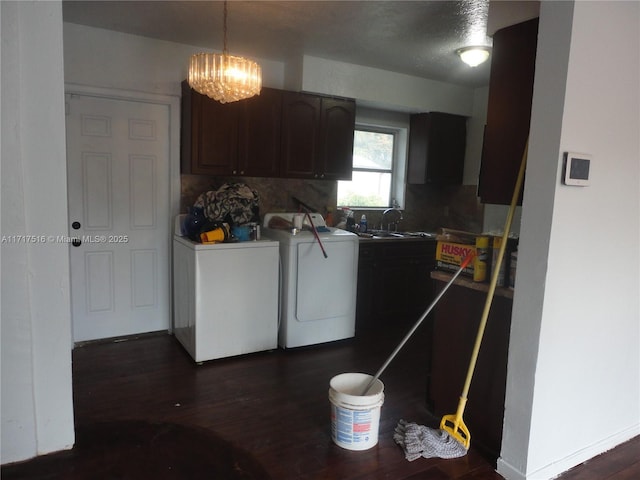 washroom with sink, dark wood-type flooring, cabinets, a notable chandelier, and washer and dryer