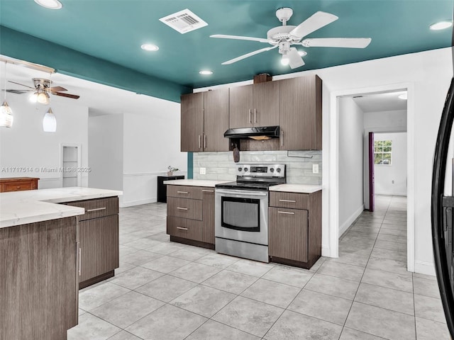 kitchen with dark brown cabinets, tasteful backsplash, light tile patterned floors, and stainless steel electric range