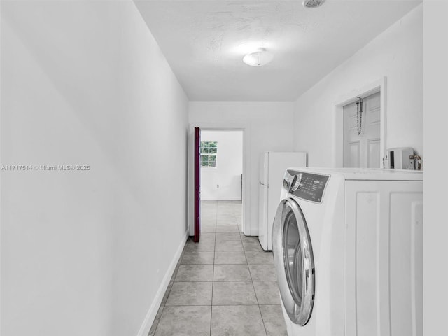 laundry room with light tile patterned floors, a textured ceiling, and washer / clothes dryer