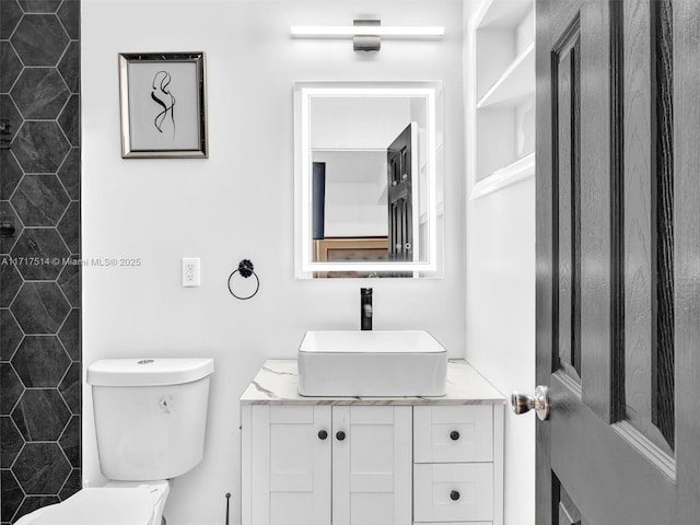 bathroom with vanity, toilet, and a shower